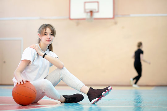 Girl in the gym playing a basketball - Powered by Adobe