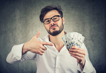 Overconfident man with pile of money - obrazy, fototapety, plakaty