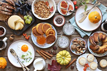 Thanksgiving Brunch. Autumn family breakfast or brunch set served on rustic wooden table. Overhead view, copy space - obrazy, fototapety, plakaty