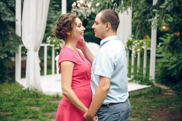 Fototapeta premium Happy and young pregnant couple in park in summer