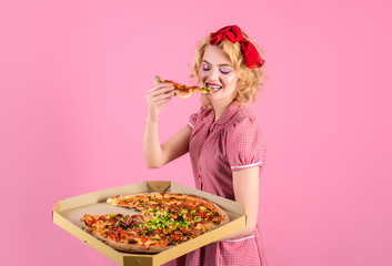 Pin up woman eating pizza. Satisfed woman with pizza. Food. Lunch. Hungry woman holds pizza in...