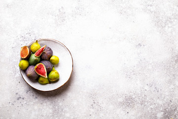 Fresh figs on plates. Berry on the stone Background.Fresh figs on plates. Berry on the stone Background.Healthy Food. Nutrition Concept.  Top View.Copy space for Text.