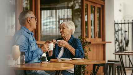 Senior couple talking over a cup of coffee at cafe