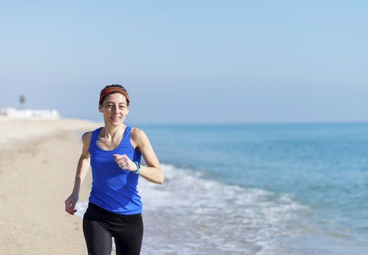 young fitness woman jogging at beach