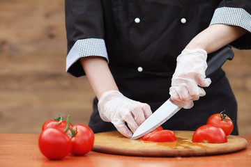 The cook cuts fresh farm vegetables