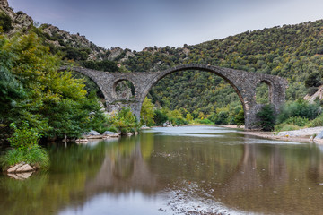 Fototapeta na wymiar Arch Byzantine stone bridge over Kompsatos river in Rodopi, Greece