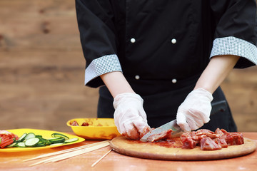 The cook cuts meat for cooking barbecue