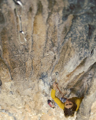 Young female rock climber on a cliff face.