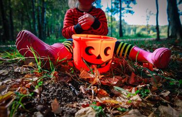 little girl play with acorns in nature, prepare for halloween