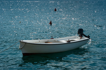 A white motor boat that is moored on the sea.