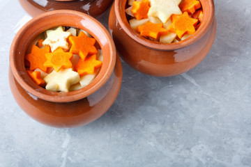 Traditional rustic home vegetable  ragout in three clay pots on beautiful stone table top.