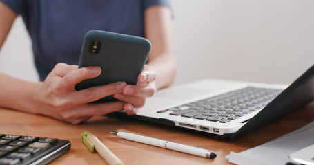 Woman work on computer and use of cellphone at home