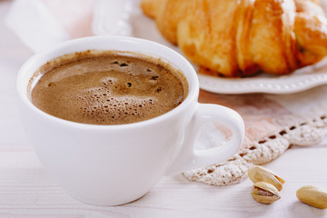 A delicious morning  frothy coffee  and croissants
