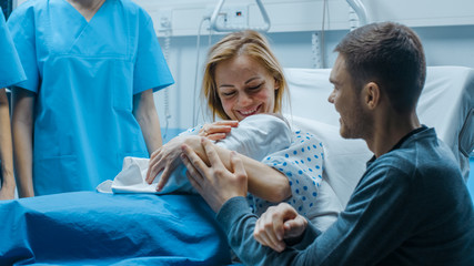 In the Hospital Mother Hold Newborn Baby, Supportive Father Lovingly Hugging Baby and Wife. Happy Family in the Modern Delivery Ward. - obrazy, fototapety, plakaty