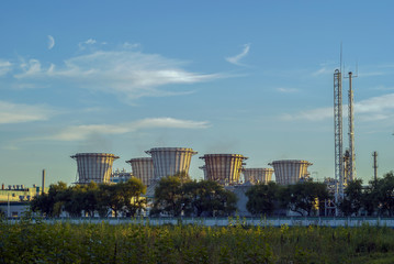 Industrial landscape with cooling towers on the greening territory of the modern chemical factory..