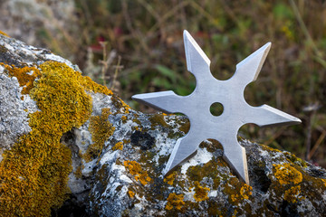 Shuriken (throwing star), traditional japanese ninja cold weapon stuck in wooden background