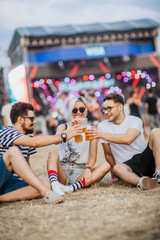 Friends drinking beer and having fun at music festival
