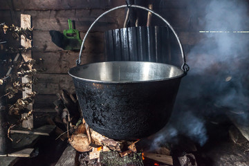 Steaming old-fashion pot with soup over fire