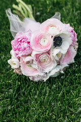 Beautiful spring bouquet with tender pink ranunculus flowers, elegant floral decoration on green grass
