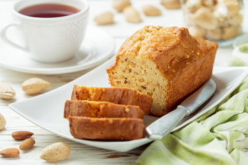 Sliced pound cake with almonds on the cutting Board. Homemade cake with nuts and honey.  Delicacy snack for tea
