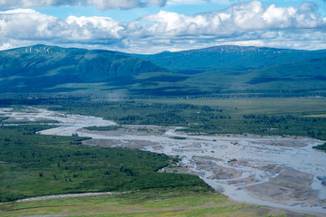 Aerial view of Katmai National Park. Braided river with sandbars, lush green mountains in...