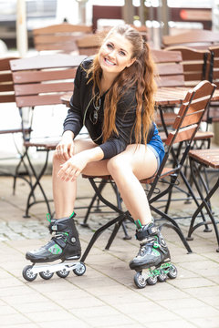 Young woman sitting wearing roller skates