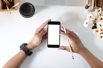Man holding mockup smartphone on office desk.