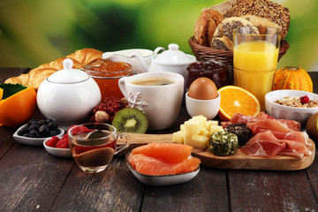 breakfast on table with bread buns, croissants, coffe and juice.