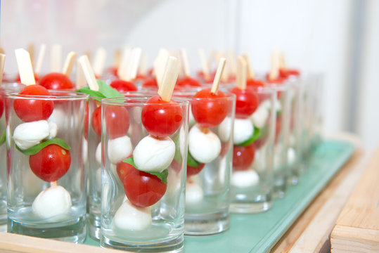 Mini caprese cherry tomatos and mini mozzarella in a glass - Finger food.