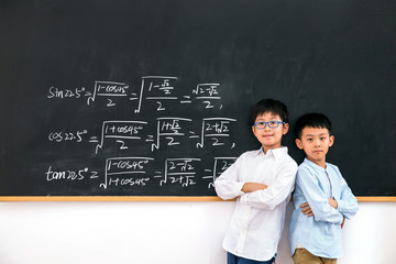 Primary school boy standing in front of the blackboard