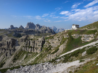 Aronzo Hütte vor Dolomiten Gipfeln im Sonnenschein mit weiss blauem Himmel, Südtirol Italien