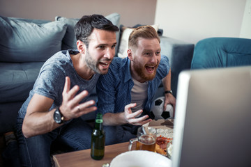 Friends enjoy the football game on TV