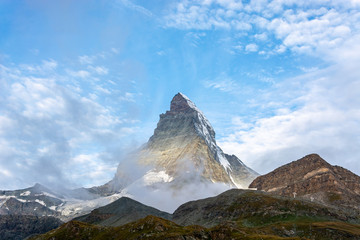 Matterhorn with clouds swirling around and blue sky