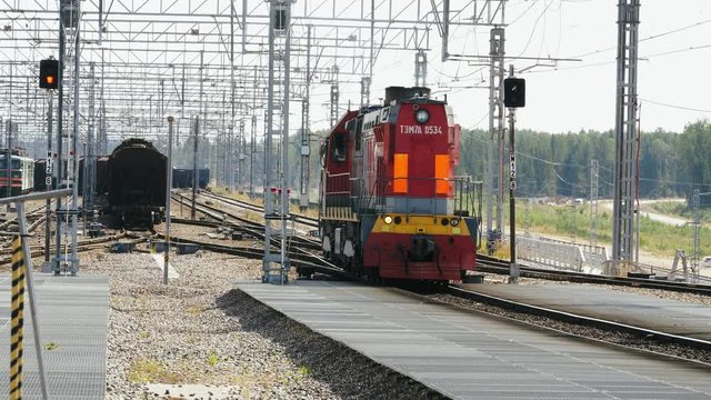 Locomotive slowly approaches the freight trains