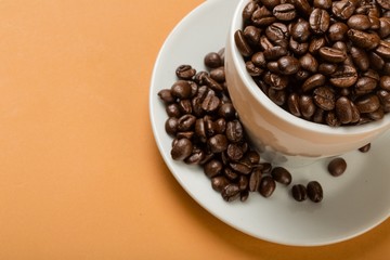 Coffee cup and saucer filled with coffee beans