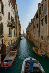 Narrow canal with green wather in Venice, Veneto, Italy