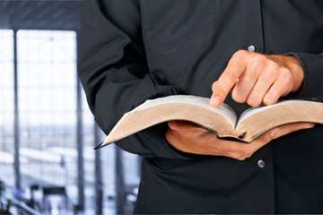 Man reading Bible on background