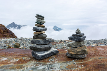 Piles of balancing stones in the mountains with clouds