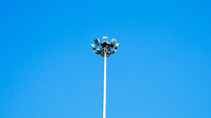 Sportlights tower over blue sky background