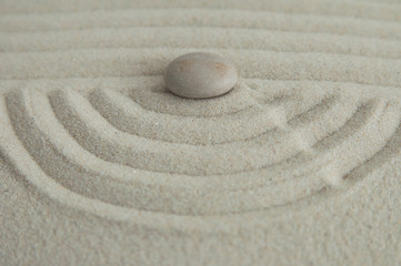 Fototapeta na wymiar Pyramids of gray zen stones on the sand with wave drawings. Concept of harmony, balance and meditation, spa, massage, relax