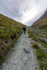 Fototapeta na wymiar Hiking trail near the Matterhorn on a cloudy day with a hiker
