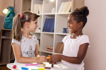Schoolgirls playing with colorful plasticine