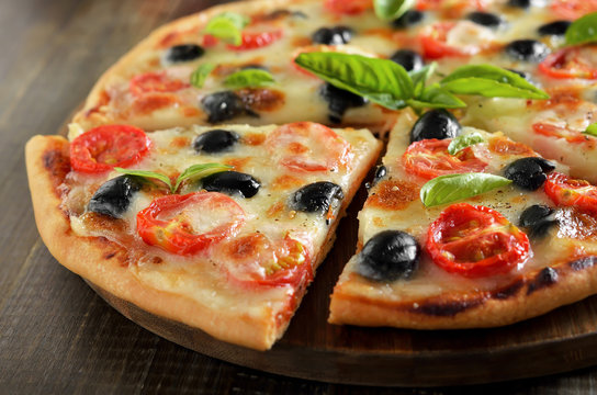 Piece of pizza with tomato and olives