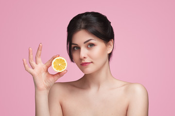 Beautiful woman with pure skin holding lemon
