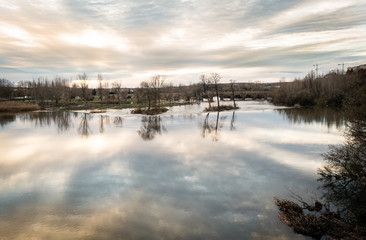 Reflection of the sky over the river Tormes on its way through Salamanca, with the Roman bridge in the background