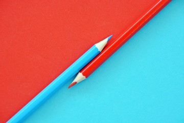 Two colored pencils split a picture in half in two different colors