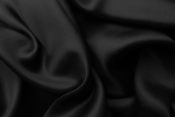 Elegant black satin silk with waves, abstract background.