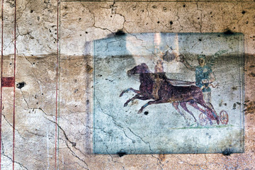 Fresco with the Aurighi in a corridor of the Aurighi tenement in the archaeological excavations of Ancient ostia - Rome