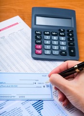 Close-up of a Businesswoman Signing a Check on Desk