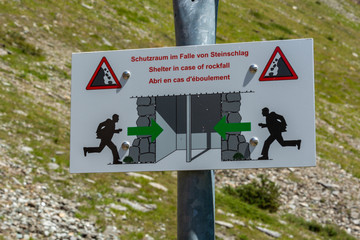 Sign for shelter in case of a rock fall in the mountains